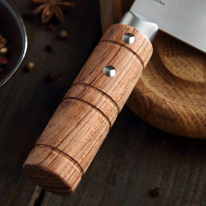 Wooden-handled knife on a wooden surface with spices in the background